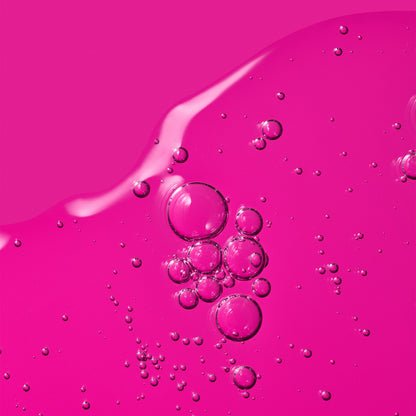 A vibrant pink gel texture with suspended air bubbles.