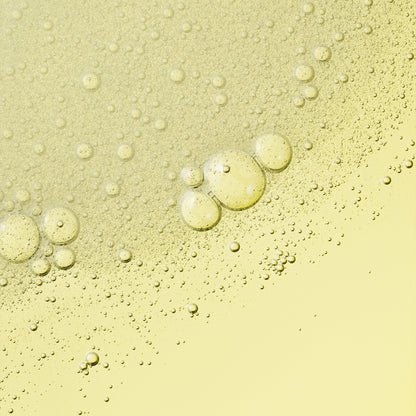 A yellow, bubbly liquid texture, with visible bubbles and droplets. 