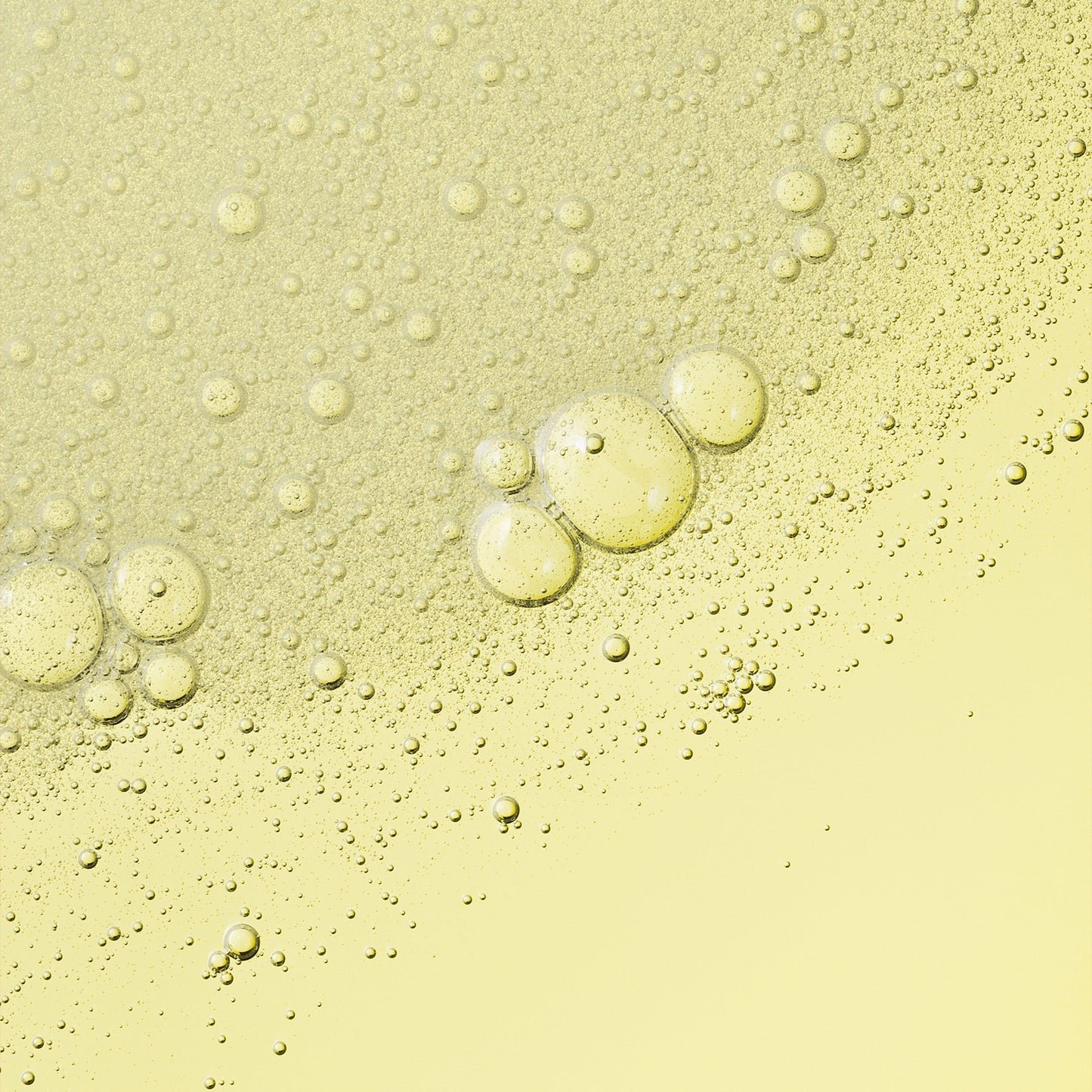 A yellow, bubbly liquid texture, with visible bubbles and droplets. 