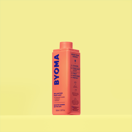A BYOMA Balancing Face Mist in an orange bottle without a cap. 