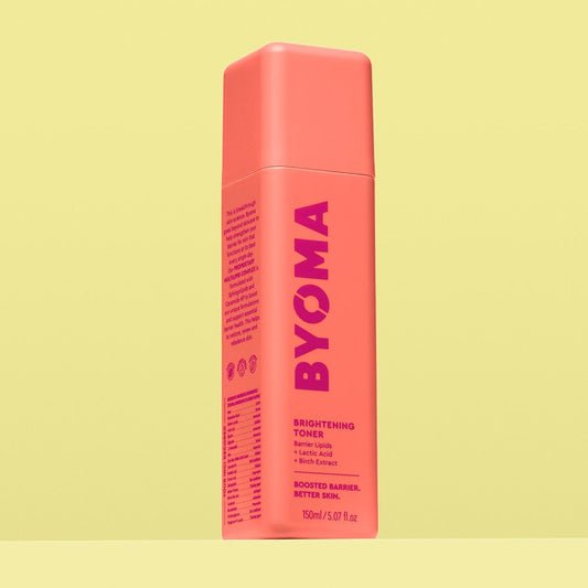 A BYOMA Brightening Toner bottle in a vibrant coral color. 
