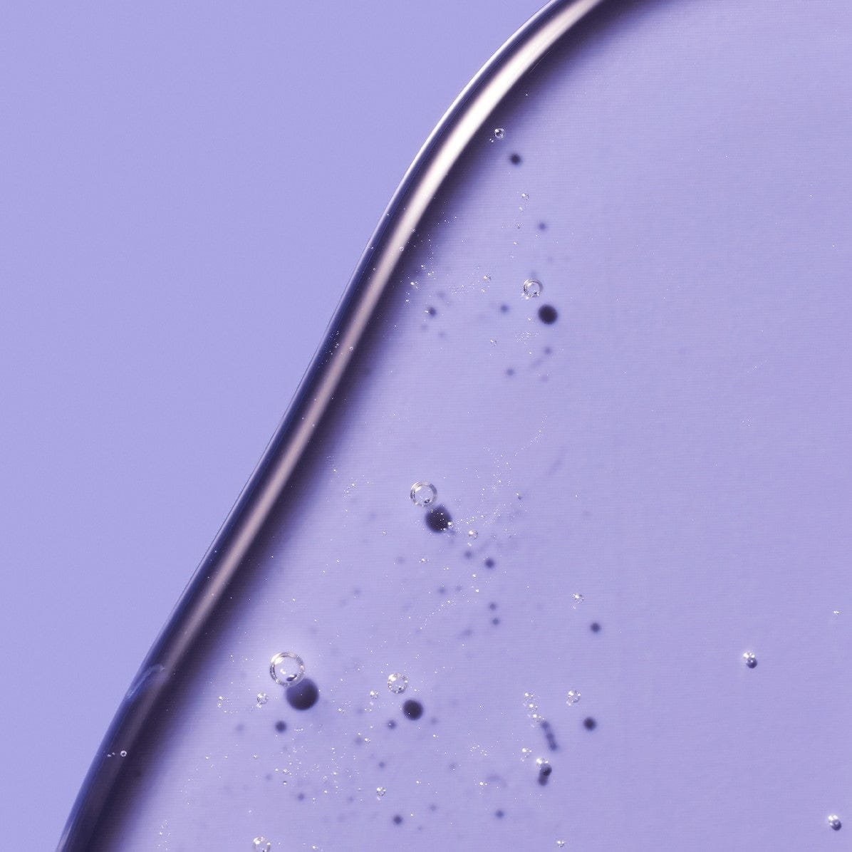 A clear, gel-like skincare product with tiny air bubbles.