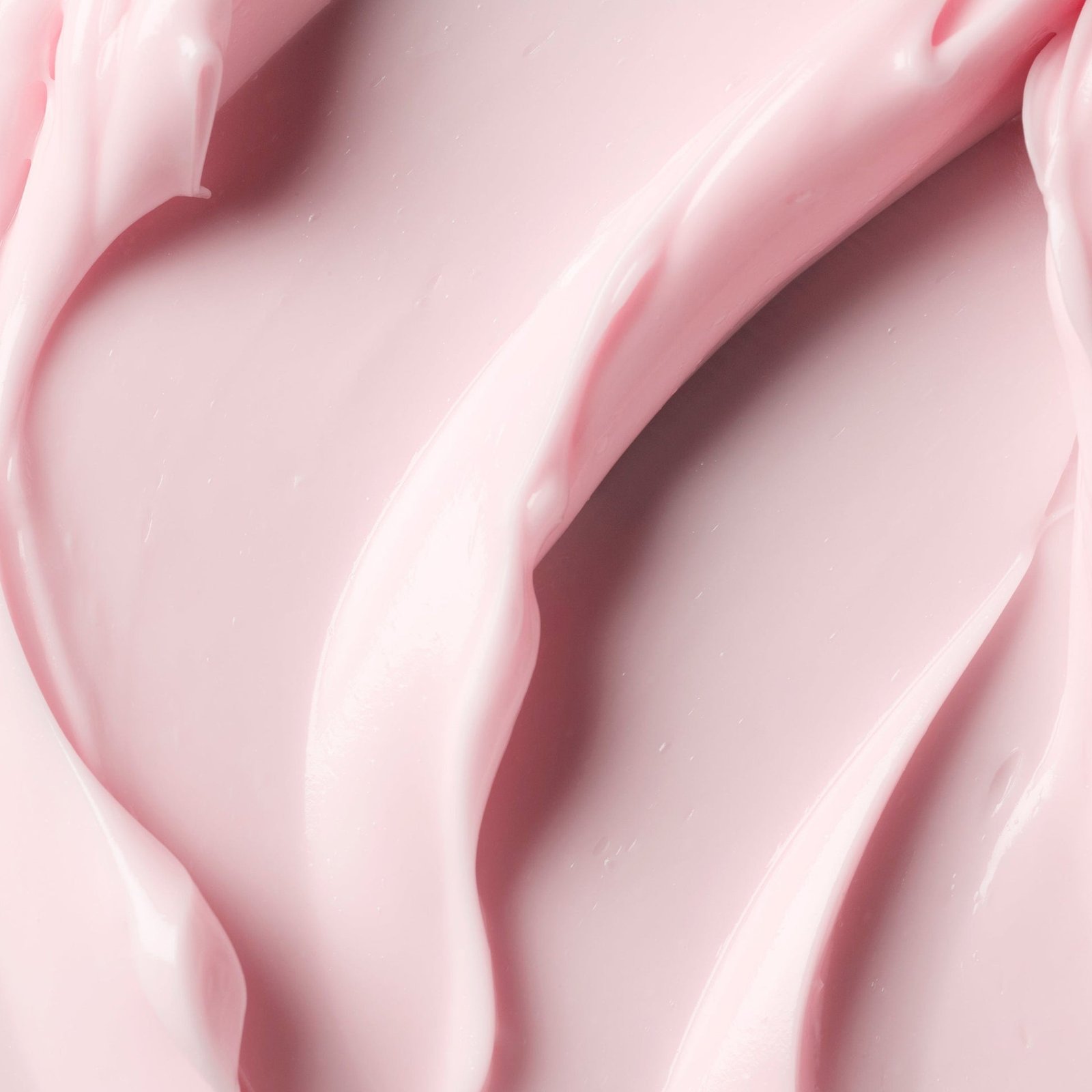 Smooth, creamy pink skincare product with soft curves.