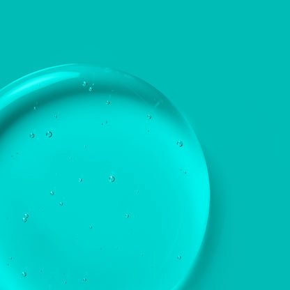 A clear, turquoise skincare gel texture with small suspended air bubbles.