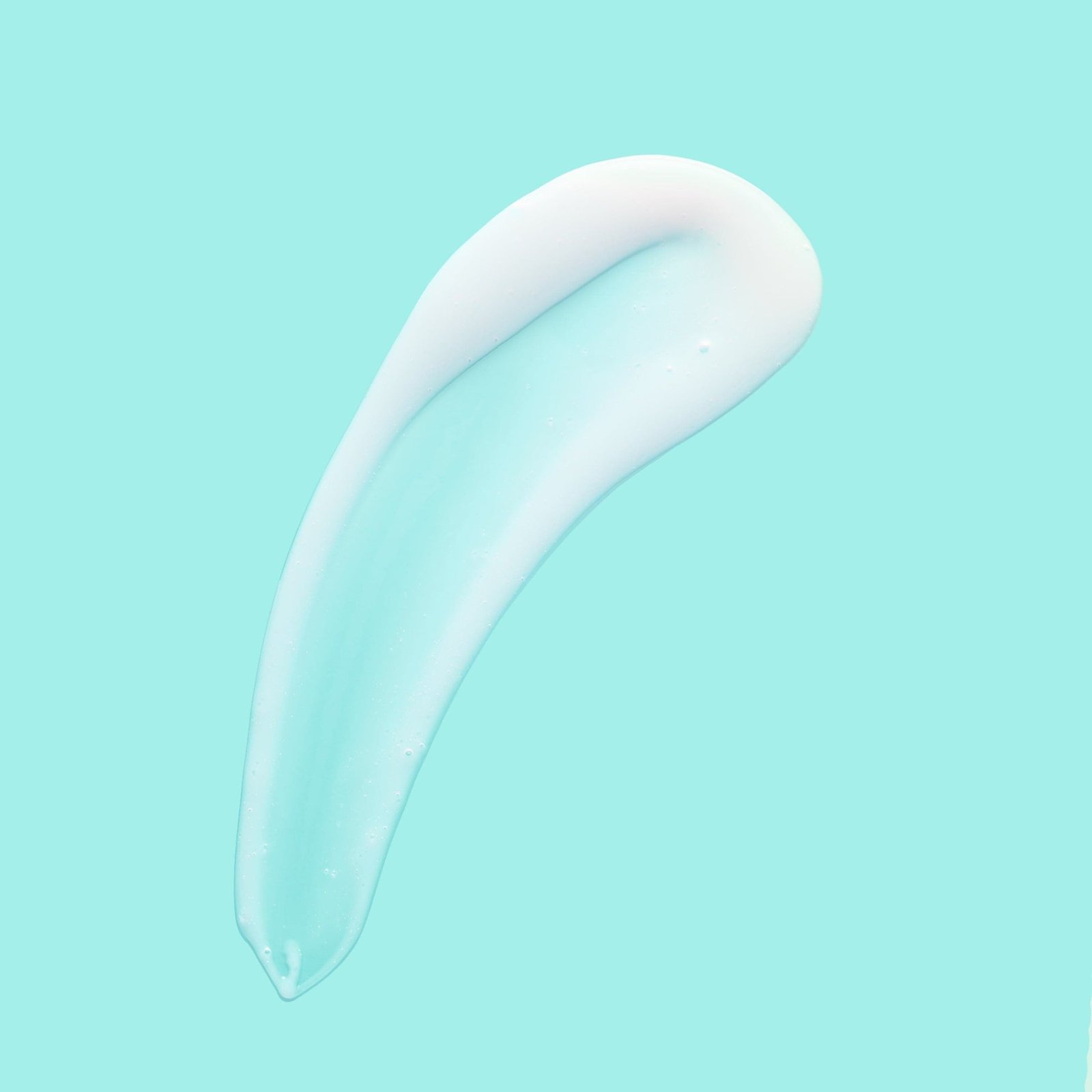 A creamy white skincare product smeared against a teal background.