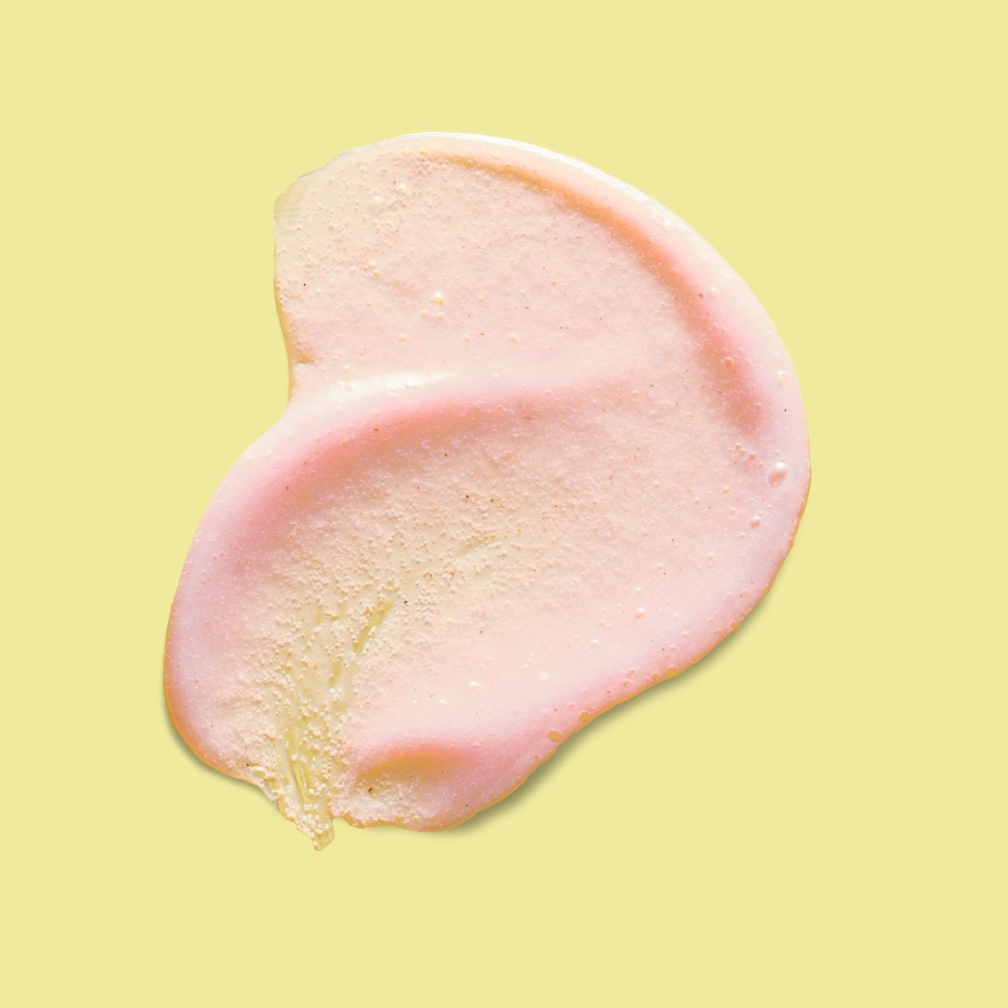 A textured swatch of pink exfoliating skincare product.