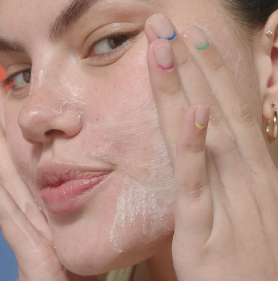 Woman applying cleanser to her face.