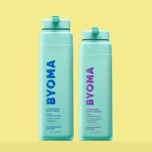 Two turquoise BYOMA products on a yellow background: Hydrating Body Wash (left) with blue text and Hydrating Body Lotion (right) with purple text. Both bottles are upright.