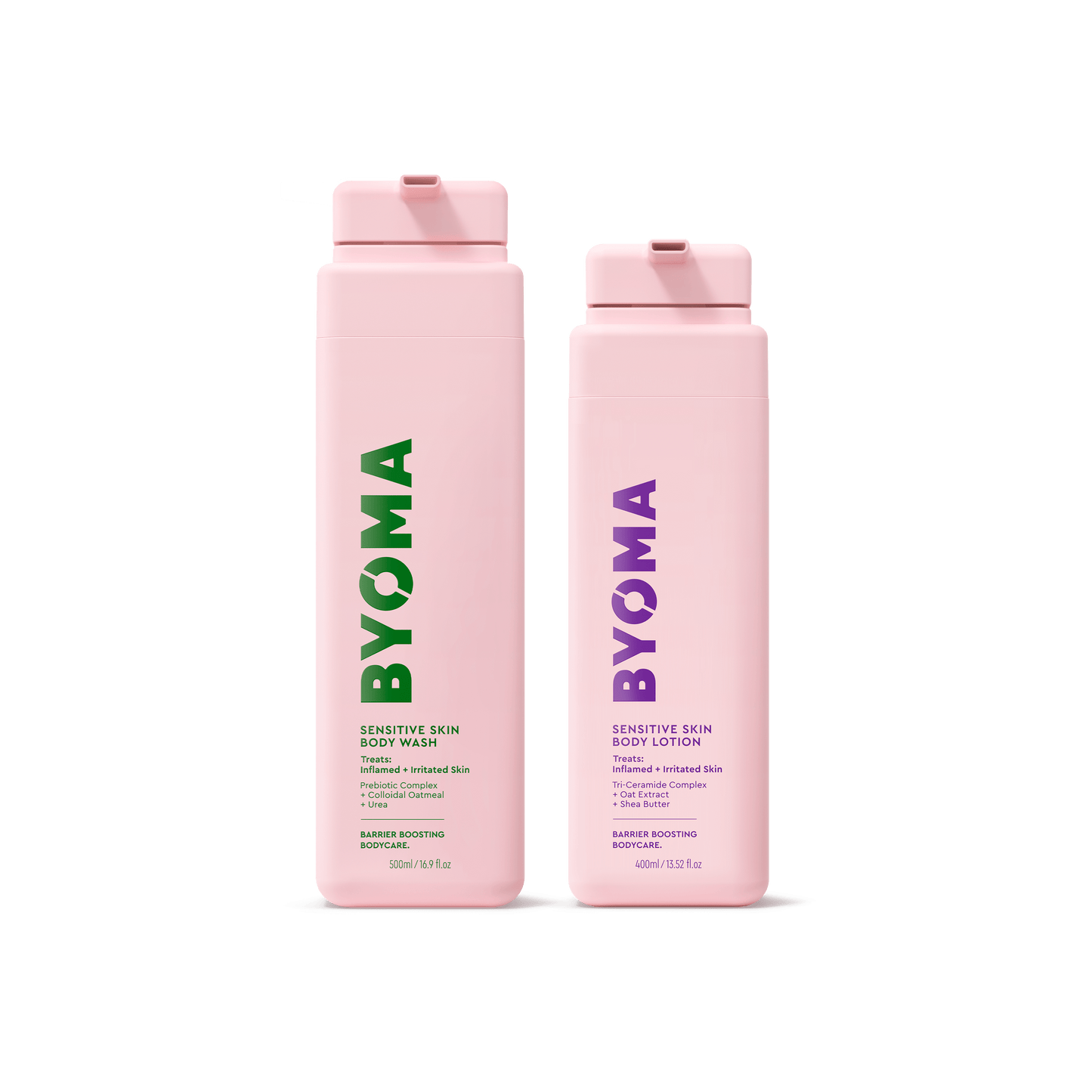 Two pink BYOMA bodycare bottles isolated on a transparent background.. Left bottle is Sensitive Skin Body Wash with green text; right bottle is Sensitive Skin Body Lotion with purple text. Both bottles are standing.
